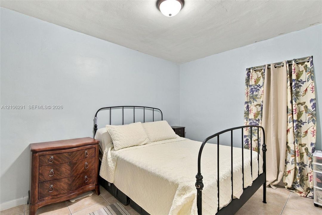 Room featuring neutral wall tones, large-format tile flooring, and a flush-mount overhead light fixture