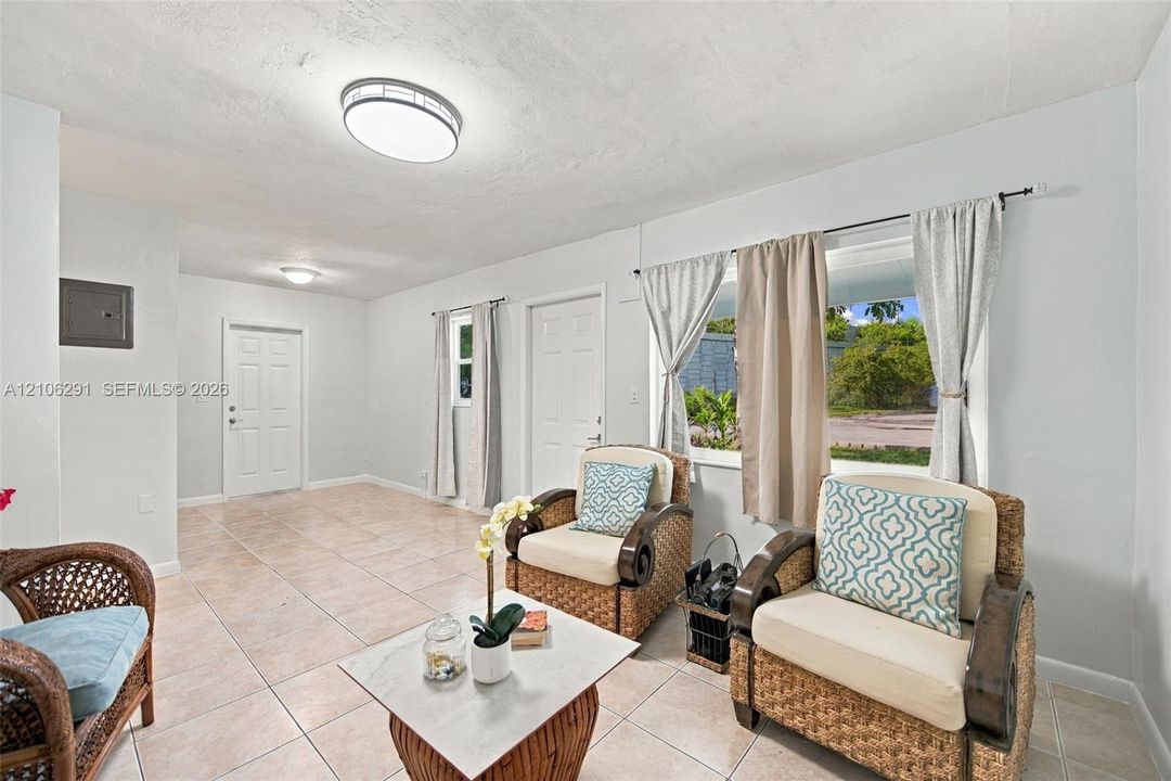 Neutral-toned ceramic tile flooring, crisp white interior paint, multi-pane window, and dual flush-mounted ceiling light fixtures