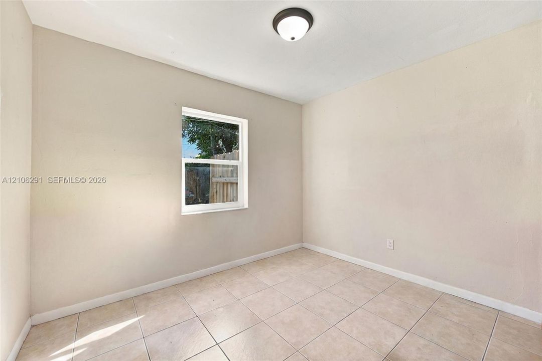 Neutral wall finish, ceramic tile flooring, and flush-mount ceiling light fixture