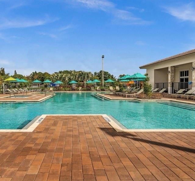 Swimming pool featuring a paver deck, integrated spa, and exterior stone masonry