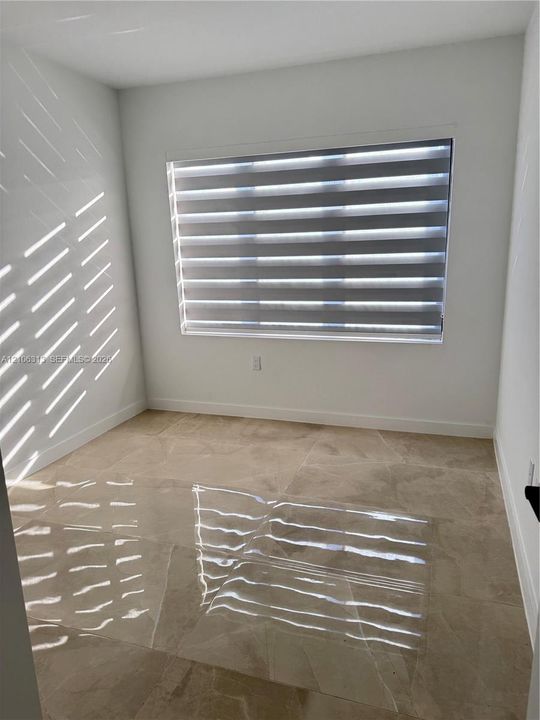 Neutral-toned large format tile flooring and crisp white wall finishes