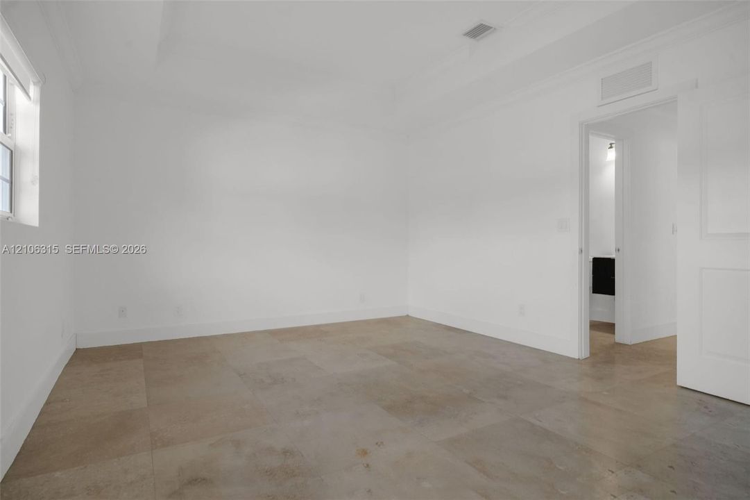 Neutral-toned tile flooring, recessed ceiling detailing, and crisp white wall finishes