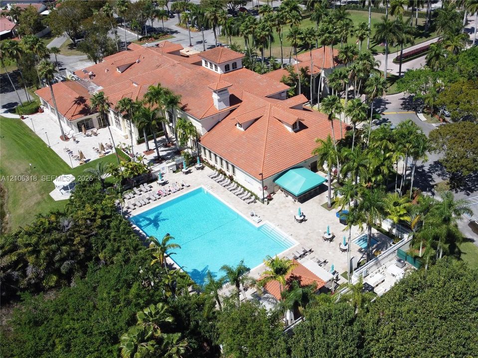 Doral Country Club with a large swimming pool with surrounding stone patio, built-in poolside shelter, and mature palm trees