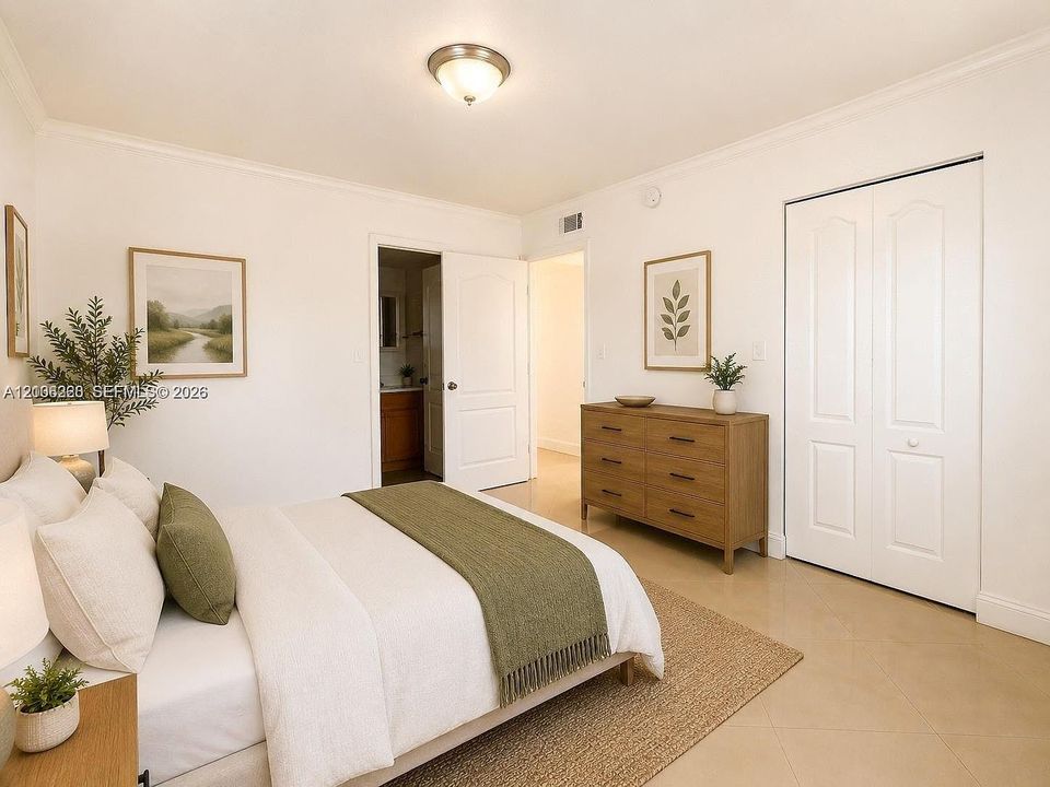 Neutral interior space featuring polished tile flooring, crisp white walls, crown molding, a central flush-mount ceiling fixture, and a white bi-fold closet door