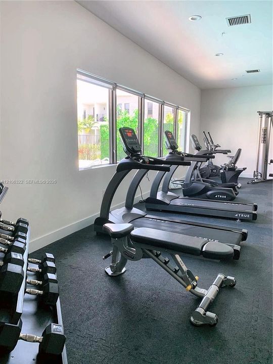 Fitness center featuring rubberized flooring, recessed lighting, and expansive windows