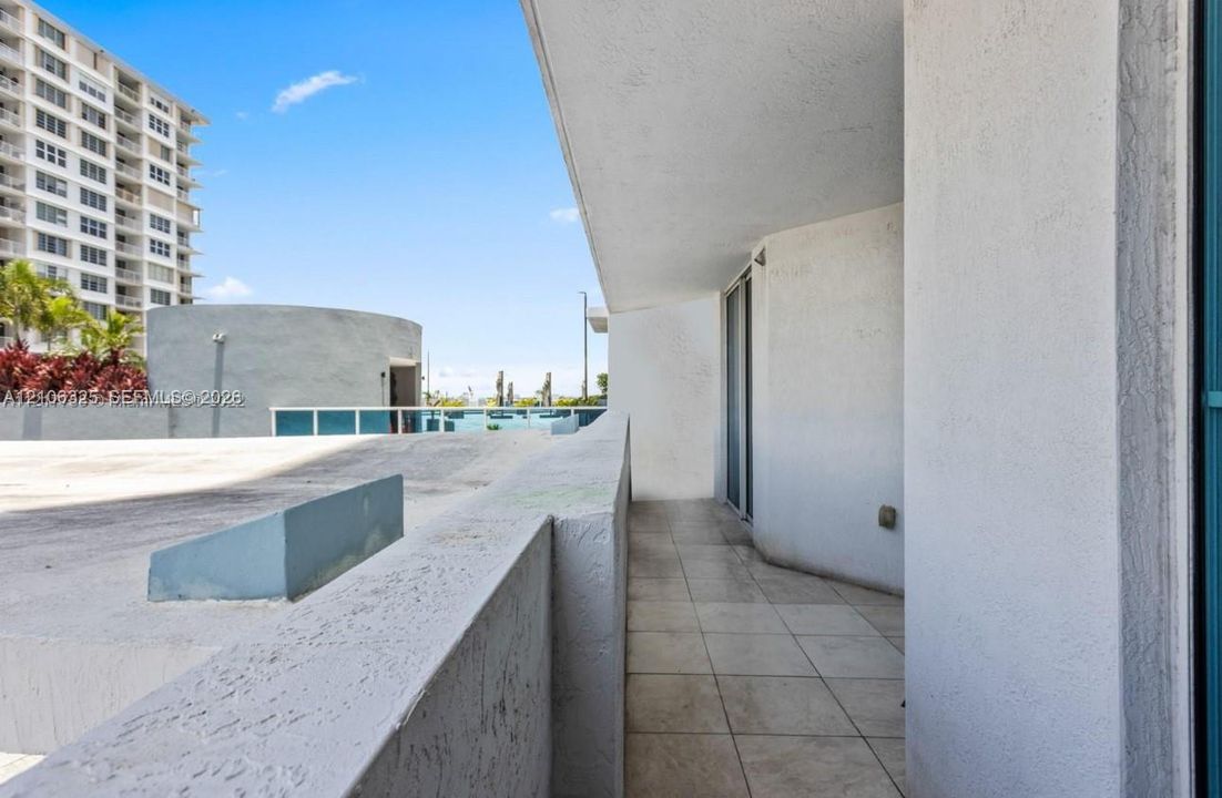 Covered balcony featuring concrete flooring and stucco wall finishes