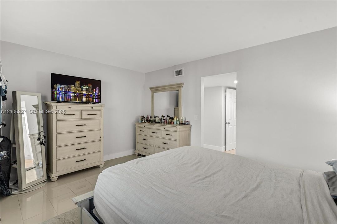 Spacious room featuring neutral wall paint, large-format tile flooring, and a six-panel interior door