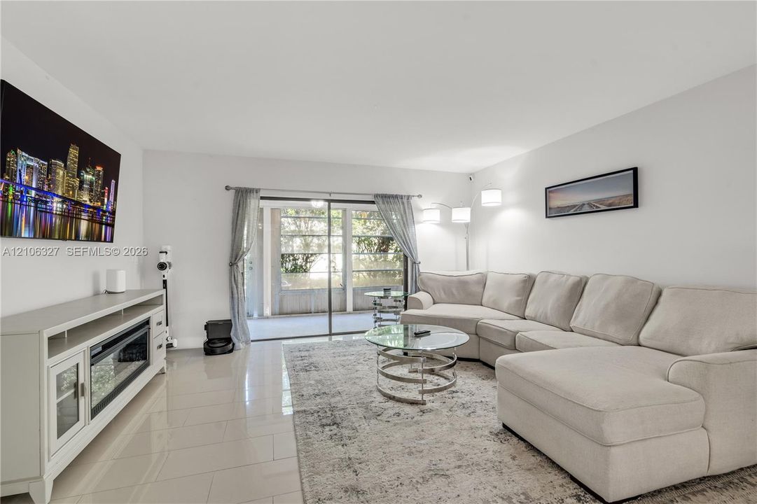 Neutral-toned ceramic tile flooring, sliding glass door with external screen enclosure, and recessed lighting