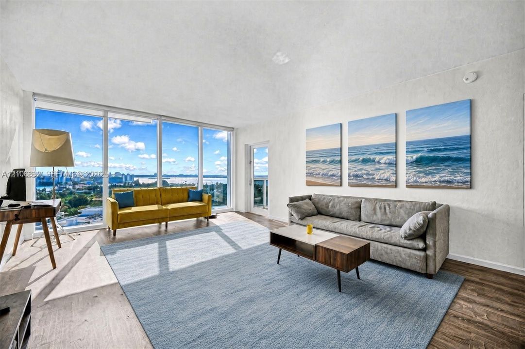 Living area featuring vaulted ceilings, floor-to-ceiling glass windows, and wood-finish flooring