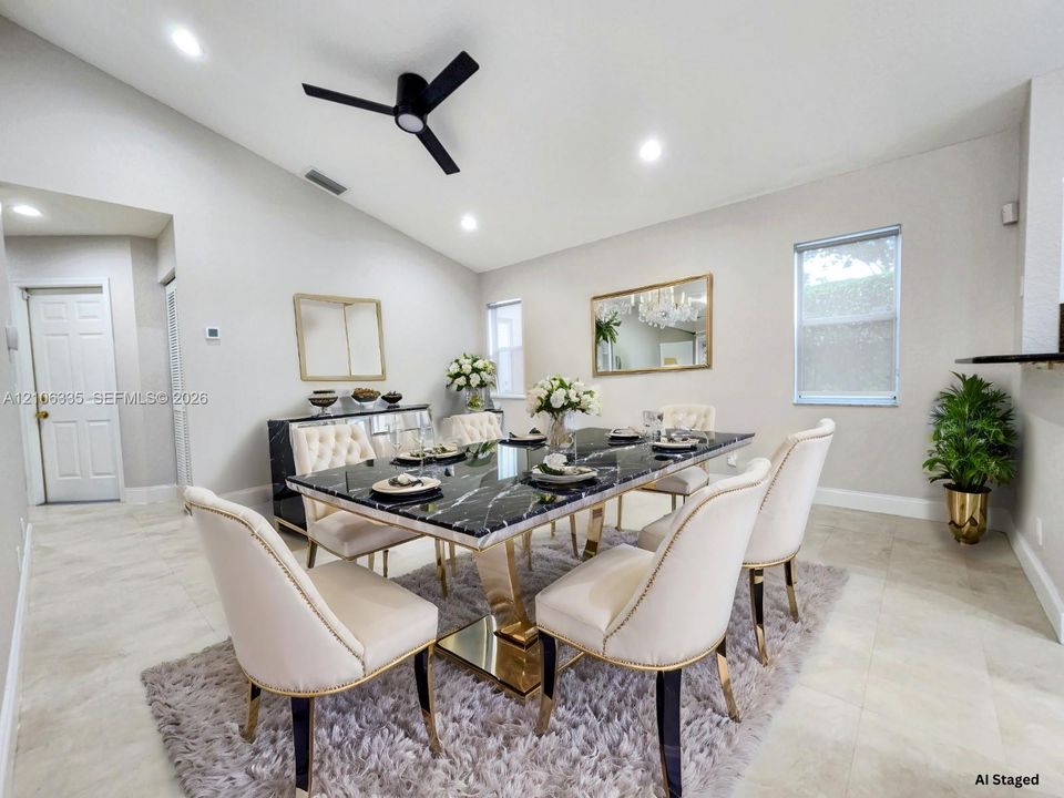 Vaulted ceilings, neutral wall tones, large-format tile flooring, matte black ceiling fan, and recessed lighting
