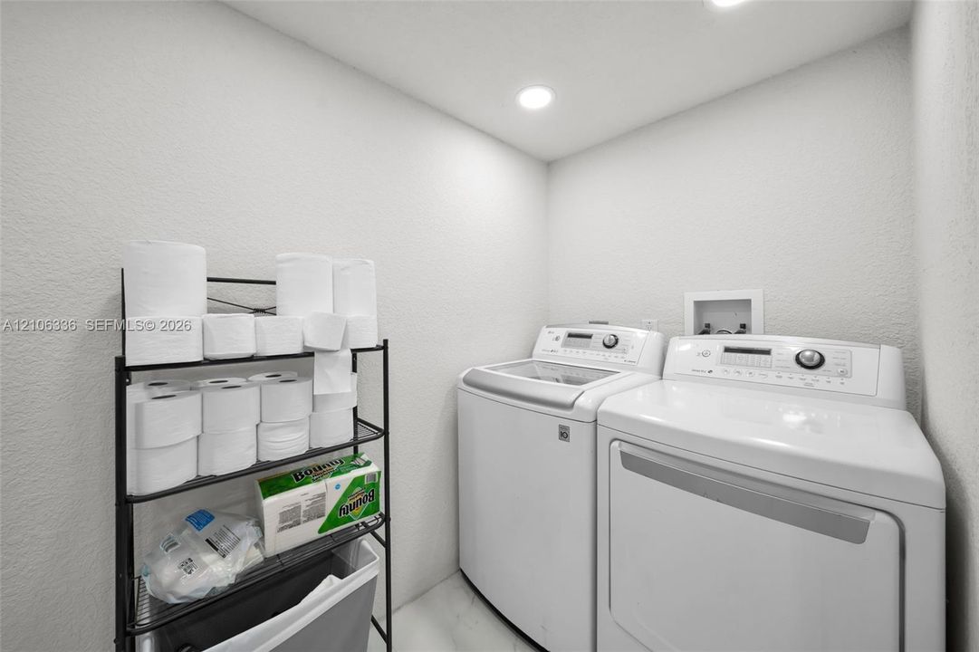 Laundry area featuring neutral wall finishes, recessed lighting, and dedicated water and electrical hookups