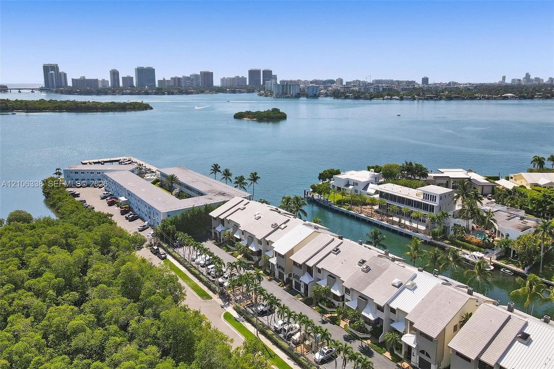 Waterfront residential property featuring multi-level structures, private boat slips, mature palm trees, and expansive bay access