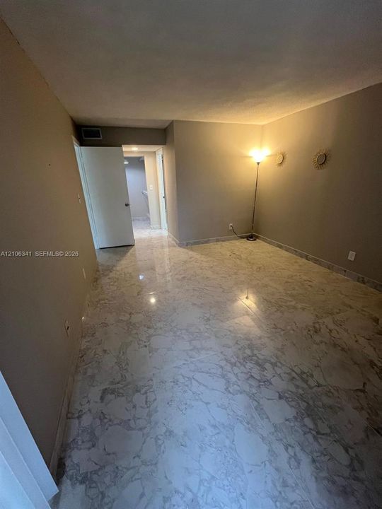 Interior room featuring polished stone-finish tile flooring and neutral-toned wall paint