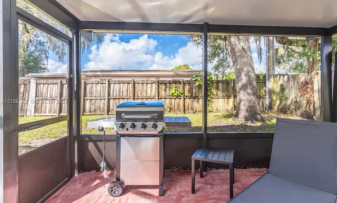 Screened patio featuring a concrete floor, dark metal framing, and a fenced backyard