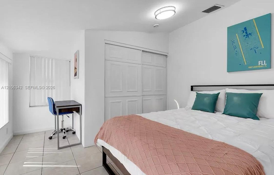 Neutral-toned ceramic tile flooring, built-in dual-panel closet with sliding doors, and ceiling-mounted flush light fixture
