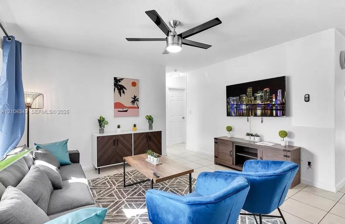 Modern five-blade brushed metal ceiling fan with integrated lighting and ceramic tile flooring