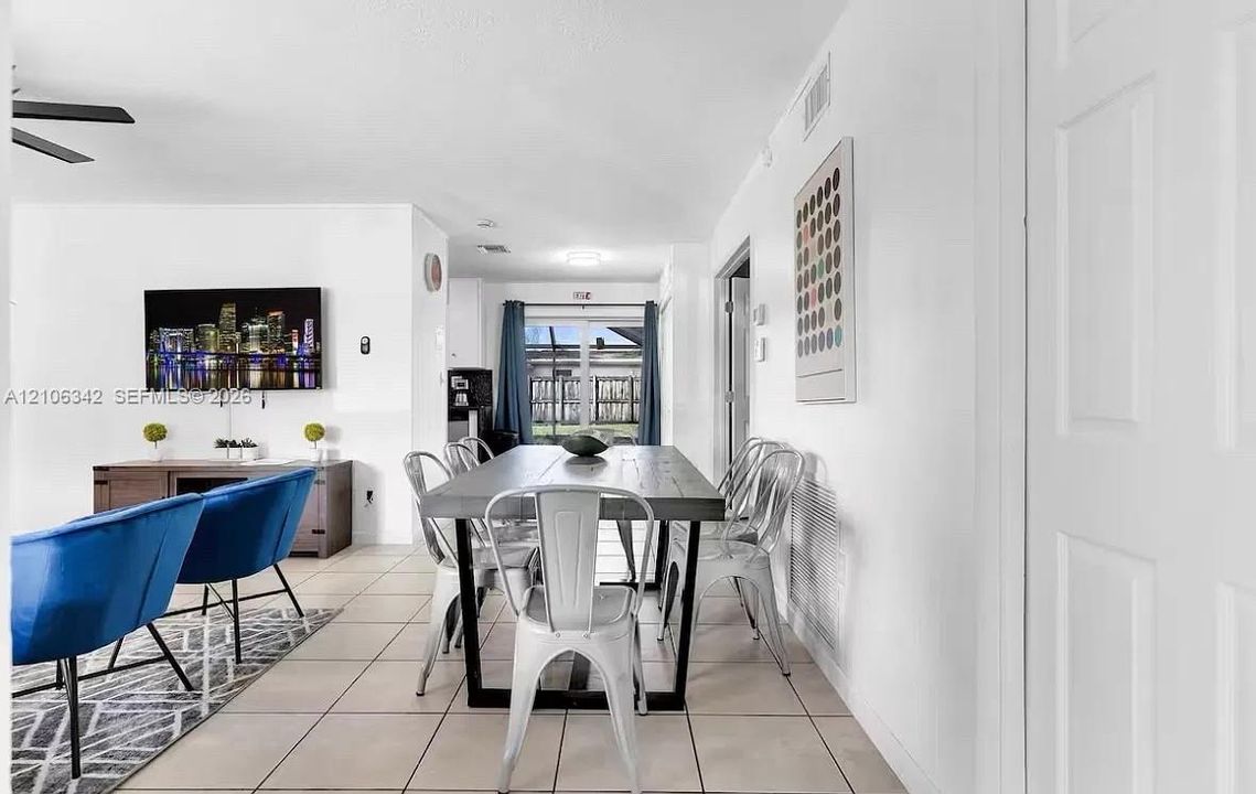 Open-concept interior featuring neutral ceramic tile flooring, recessed lighting, and a sliding glass door providing external access