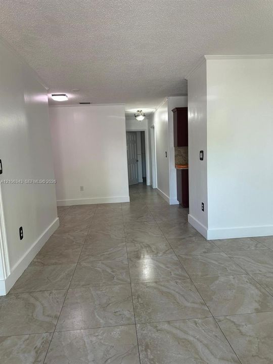 Neutral-toned tile flooring, white wall finishes, and ceiling-mounted light fixtures