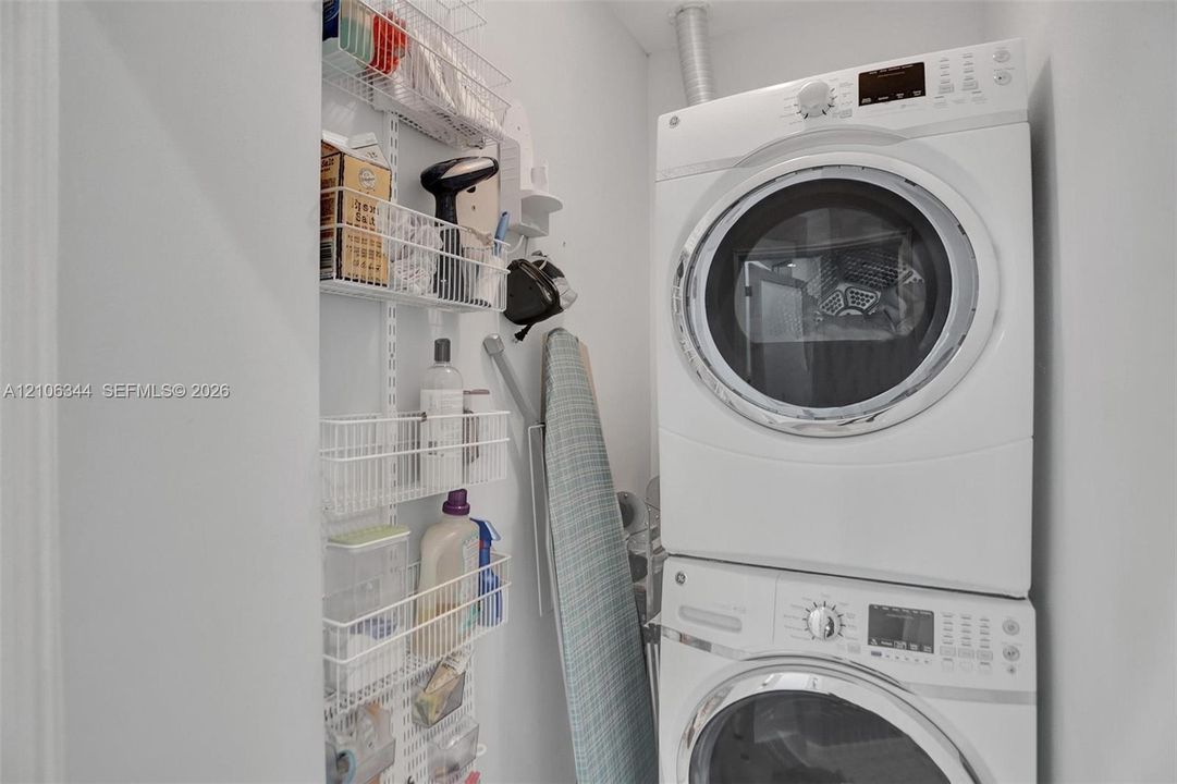 Stacked front-load washer and dryer unit with wall-mounted wire storage shelving