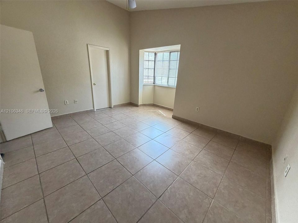 Interior space featuring vaulted ceilings, ceramic tile flooring, and a recessed bay window