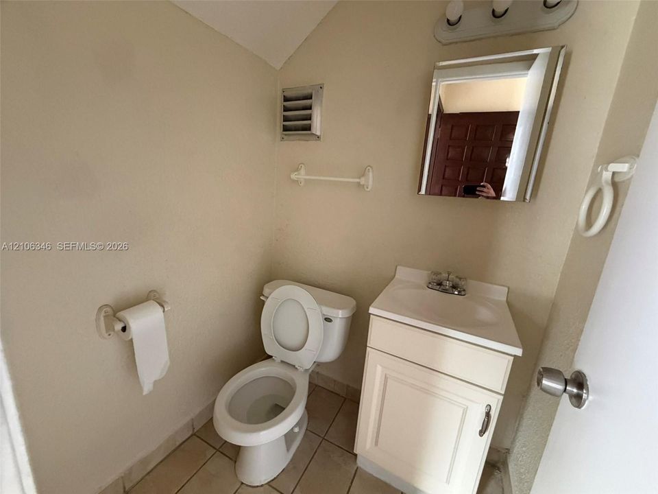 Bathroom featuring a vanity cabinet with an integrated sink, polished chrome faucet, wall-mounted medicine cabinet, and tile flooring