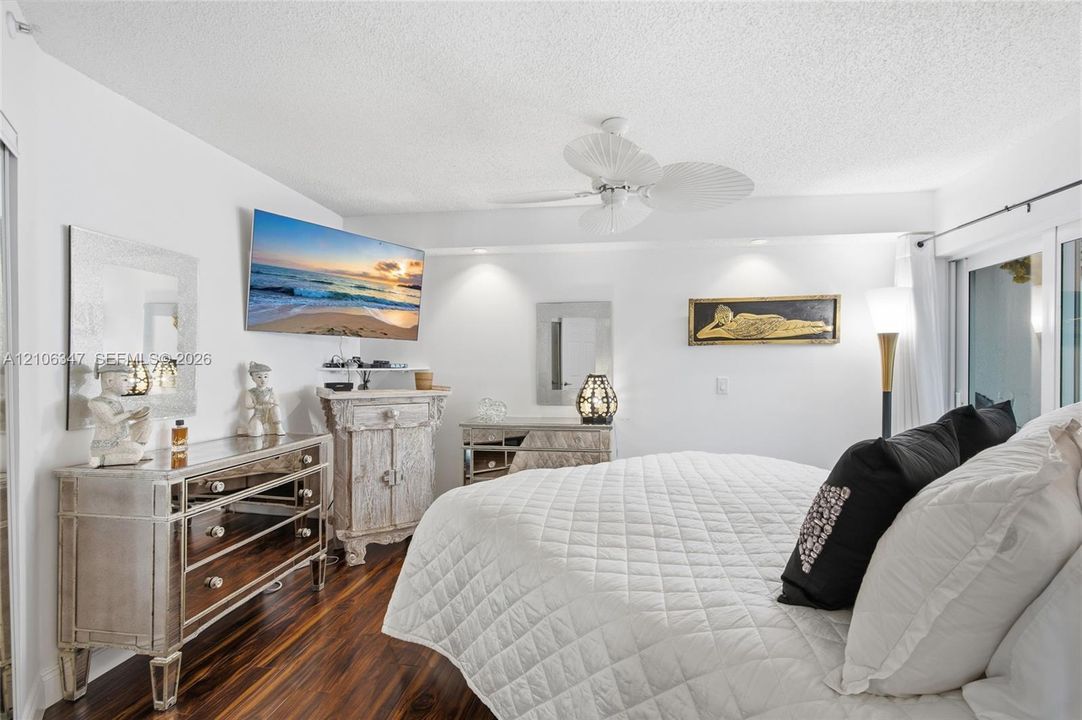 Wood-finish flooring, recessed ceiling lighting, and a white multi-blade ceiling fan