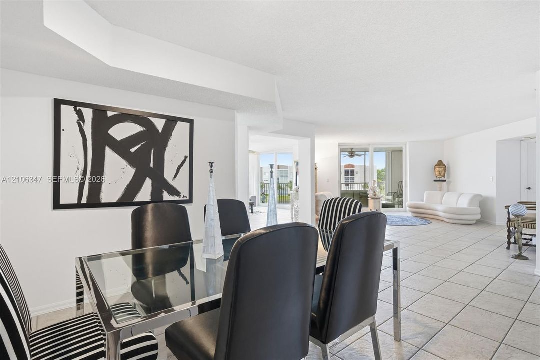 Open-concept interior featuring large-format ceramic tile flooring, recessed ceiling design, and floor-to-ceiling glass sliding doors