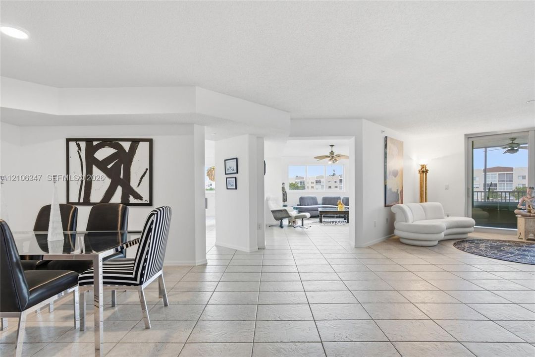 Neutral ceramic tile flooring, recessed lighting, and sliding glass balcony doors