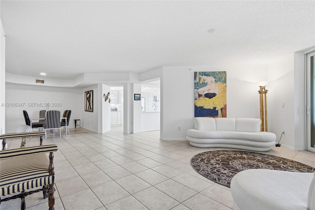 Open-concept interior featuring large-format ceramic tile flooring, recessed lighting, and sliding glass doors