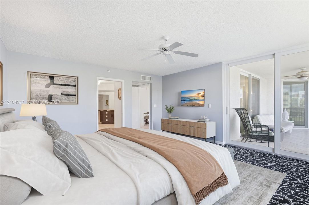 Spacious room featuring a ceiling fan, wall-to-wall carpeting, and expansive sliding glass doors providing outdoor access