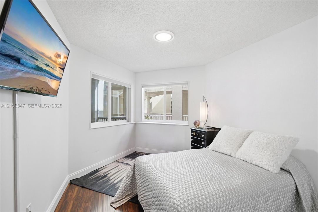 Room featuring wood-finish flooring, dual windows, and recessed ceiling lighting