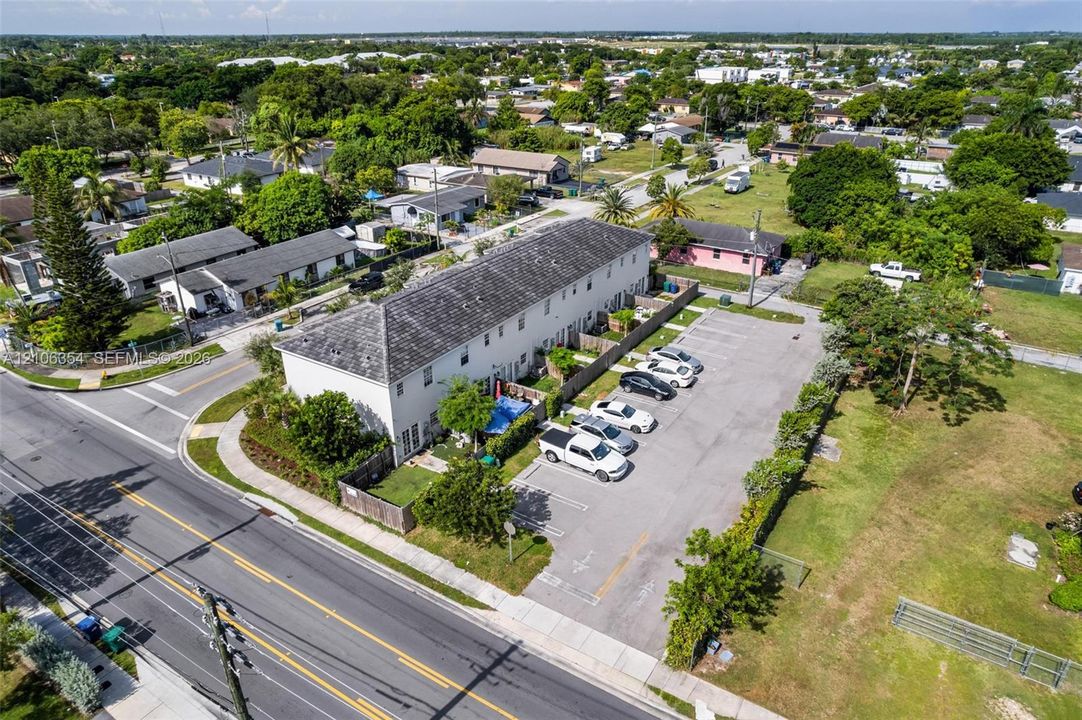 Multi-story townhome exterior featuring an asphalt shingle roof and dedicated surface parking area