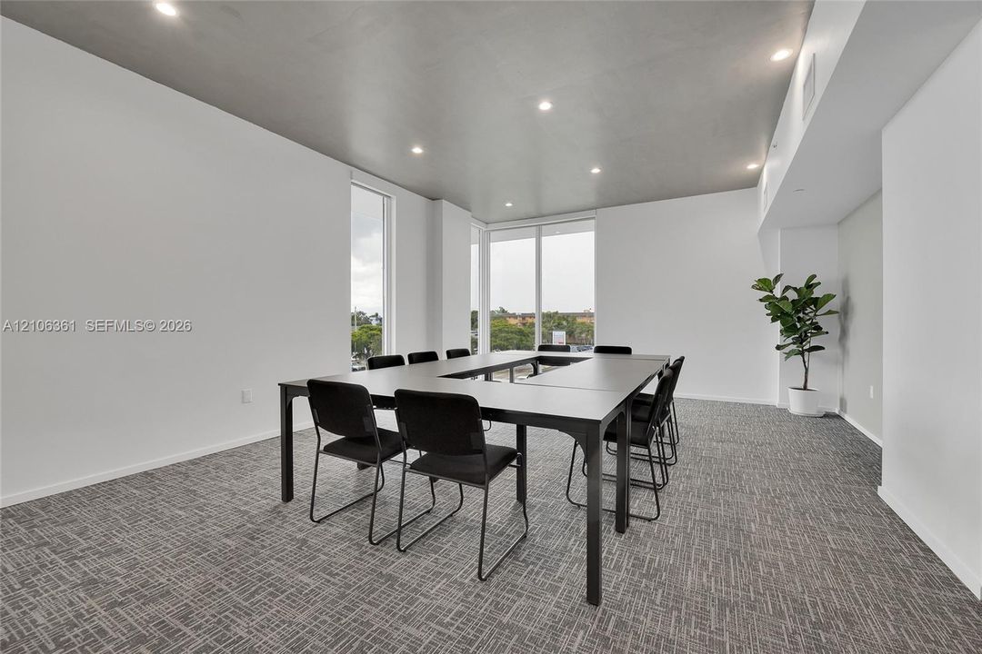 Interior space featuring floor-to-ceiling windows, high ceilings with recessed lighting, and neutral patterned carpeting