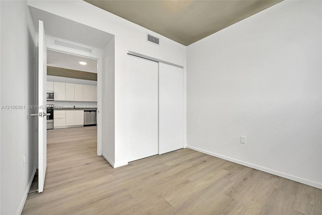 Interior space featuring wood-finish flooring, sliding door closet, and a neutral color palette
