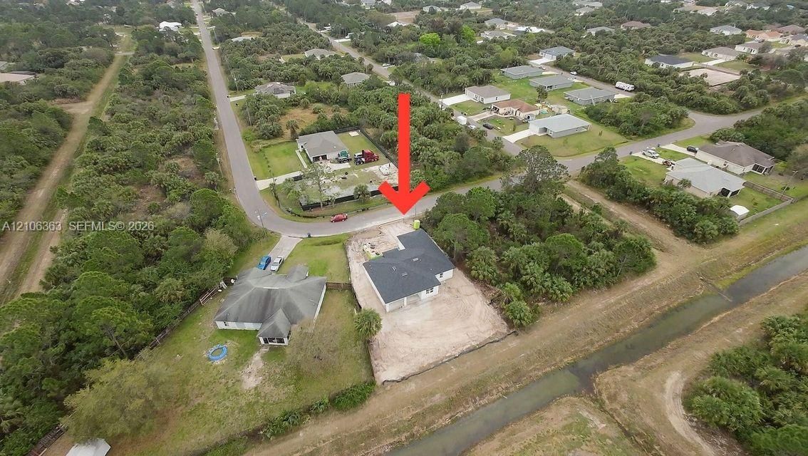 Aerial perspective of a single-story residence on a corner lot featuring a multi-gabled roofline and an attached garage