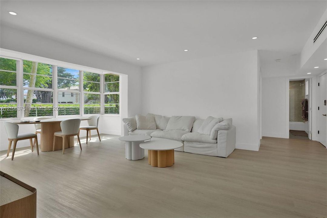 Expansive interior space featuring wood-finish flooring, recessed lighting, and a large multi-pane bay window