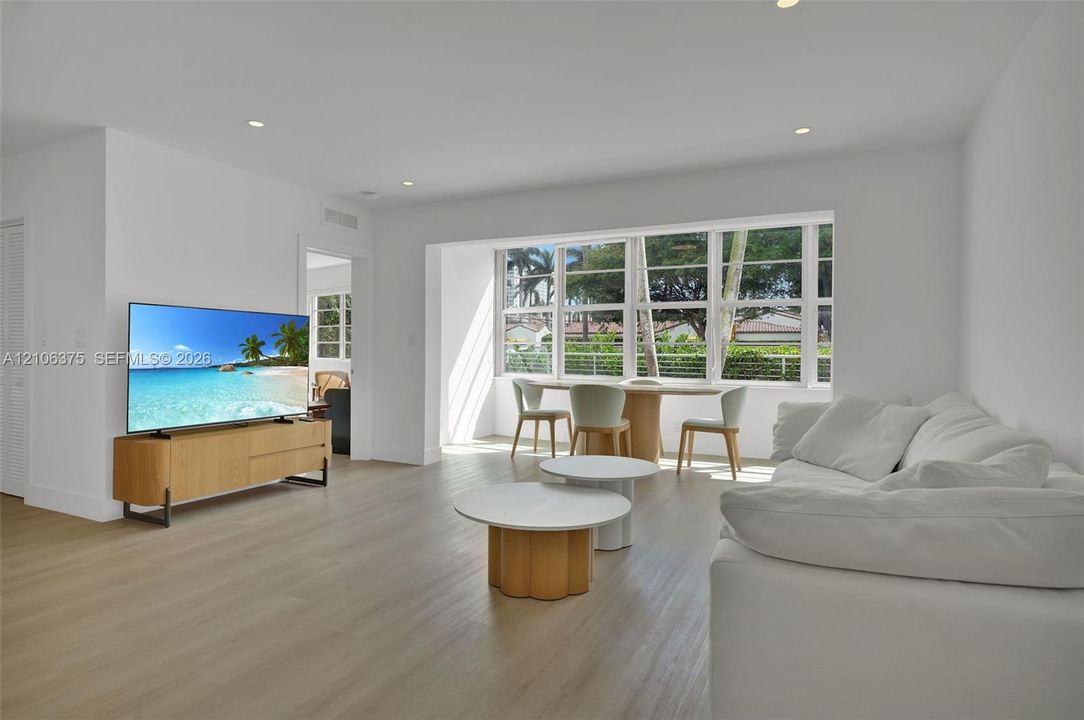 Living space featuring wood-finish flooring, recessed lighting, and expansive multi-pane windows