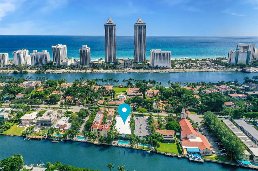 Aerial perspective featuring waterfront property with direct bulkhead access, a swimming pool, and proximity to the coastline