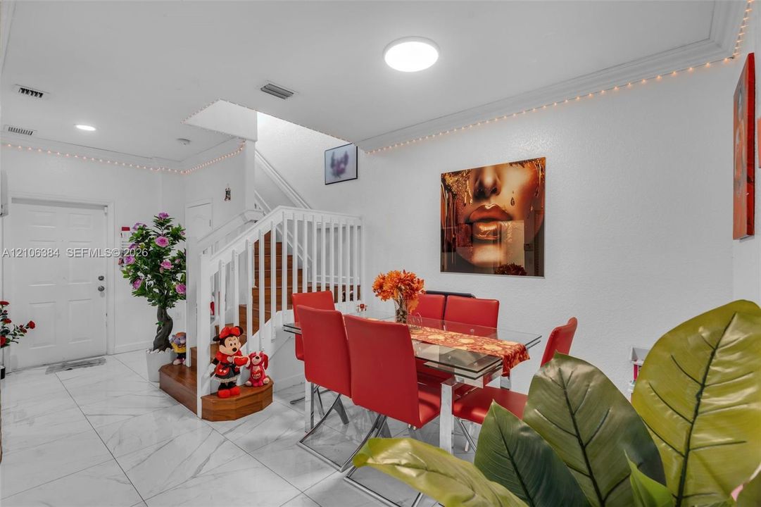 Interior area featuring white tile flooring, flush-mount ceiling lighting, and a staircase with white balusters and wood-finish stair treads