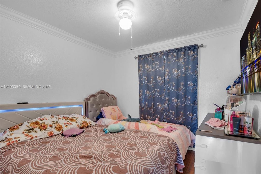 Interior space featuring crown molding, wood-finish flooring, and ceiling-mounted light fixture