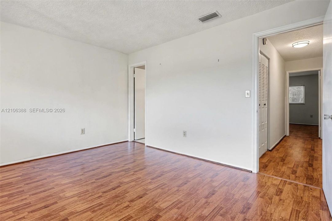 Interior space featuring wood-finish flooring, white walls, and a white bi-fold door closet