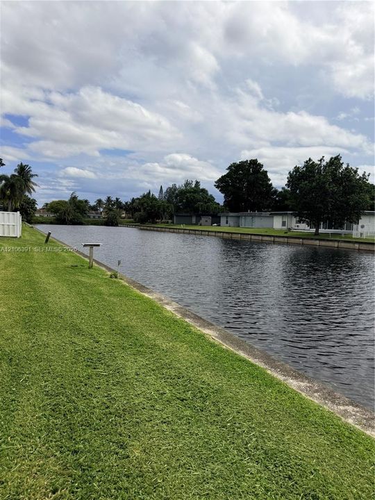 Waterfront lot featuring a concrete bulkhead and expansive grass lawn