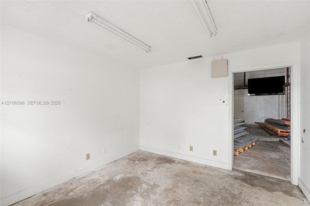 Interior space featuring white walls, concrete flooring, and linear ceiling-mounted lighting