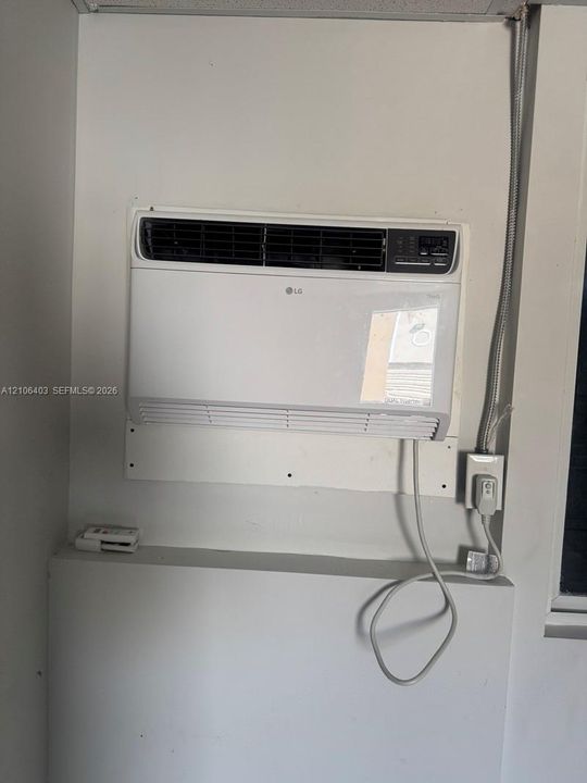 Wall-mounted LG air conditioning unit with integrated digital controls and standard electrical outlet connection