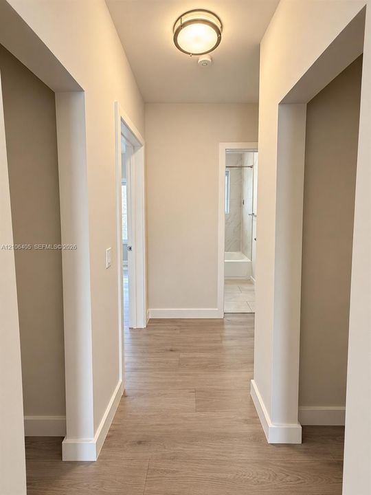 Neutral wall color, wood-finish flooring, and flush-mount ceiling lighting