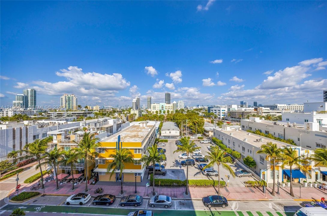 Elevated urban landscape featuring a cityscape backdrop, palm-lined streets, and surrounding multi-story commercial and residential architecture