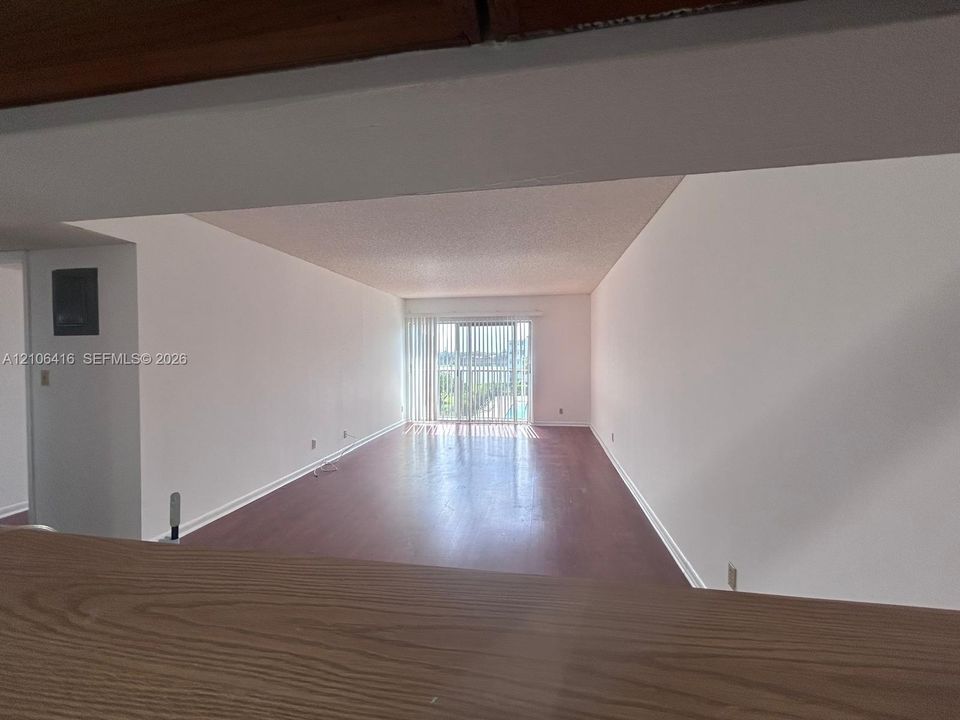 Open-concept living space featuring wood-finish flooring and floor-to-ceiling sliding glass doors