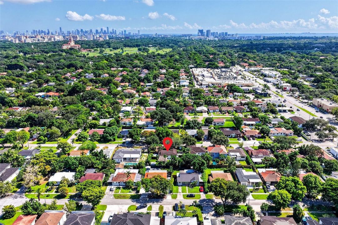 Aerial perspective featuring mature trees, a rectangular parcel, and a prominent skyline backdrop