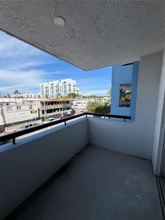 Private balcony featuring a concrete floor, recessed lighting, and a metal railing