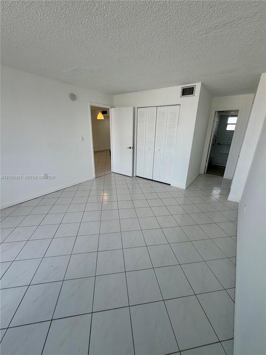 Interior space featuring ceramic tile flooring, bifold closet doors, and solid-core interior doors